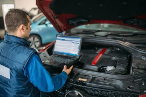 Engineer makes computer diagnostics of car engine Foto stock