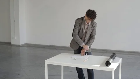 Engineer makes a drawing at a white table in the room Stock Footage 124941335