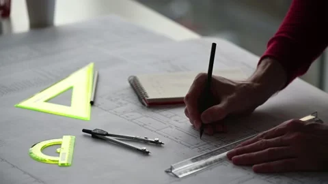 Engineer makes edits to blueprint with a pencil Stock Footage 169602240