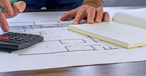 The engineer makes notes on a paper drawing Stockbeeldmateriaal 239169064