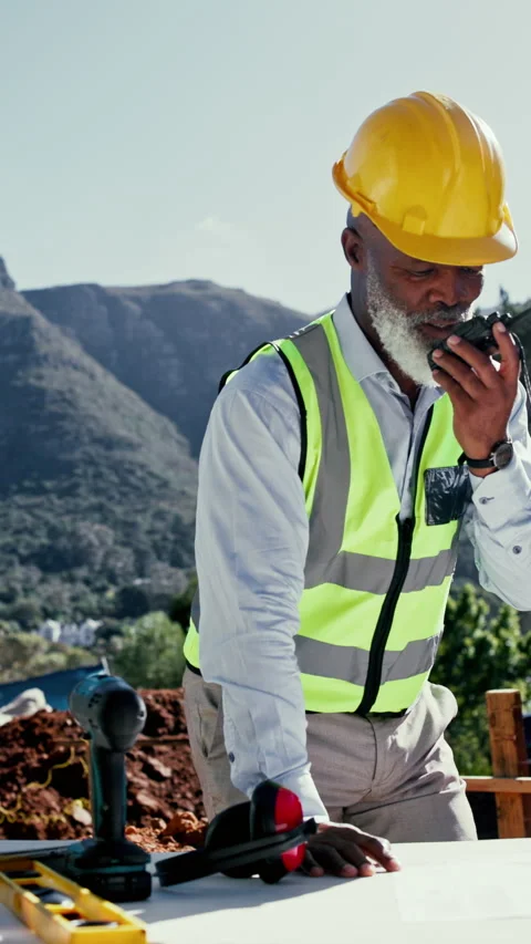 Engineer, man and blueprint at construction site with radio, communication and Stock Footage 340450805