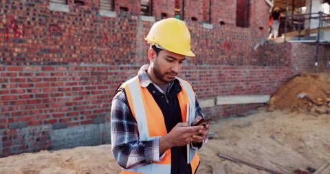 Engineer, man and inspection at construction site with phone, text message and Stock Footage 336209978