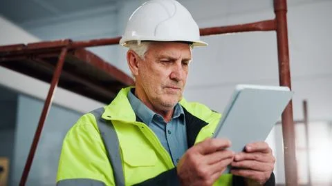 Engineer, man and research at construction site with tablet, app or check Stock Photos