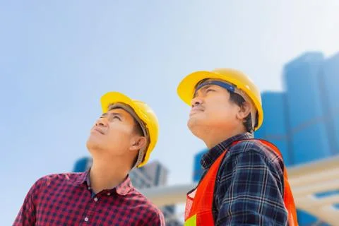 Engineer man and worker checking and planning project at construction site Stockfoto's