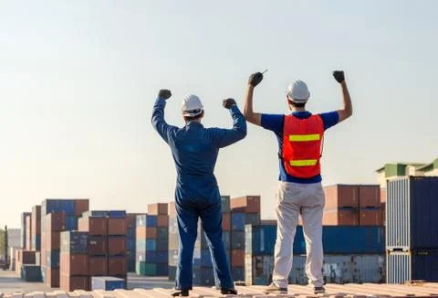 Engineer Man and worker foreman celebration on a containers box at cargo 写真素材