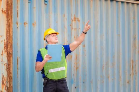 Engineer man in hard hat holding clipboard checklist and pointing to the sky  库存照片