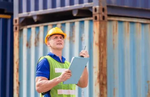 Engineer man in hard hat holding clipboard checklist and talks on two-way radio Photos