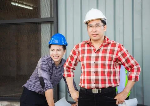 Engineer man in hard hat standing and looking at camera at construction site 写真素材