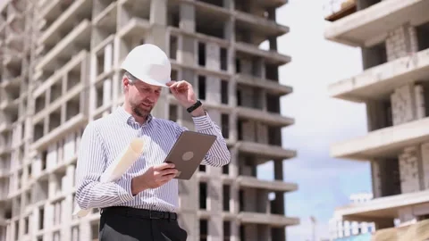 Engineer man in helmet use tablet computer for controls construction Stock Footage 340067898