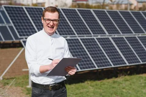 Engineer. Man near solar panel. Worker with a folder. Stock Photos