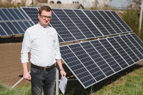Engineer. Man near solar panel. Worker with a folder. Stock Photos
