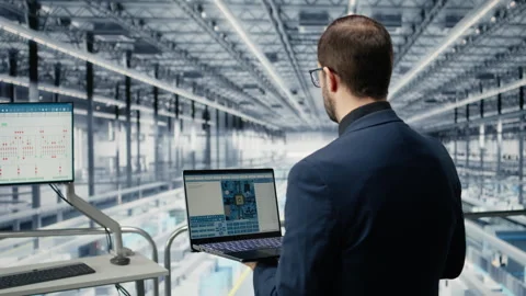 Engineer man reviewing semiconductors smart factory schematics with laptop Stock Footage 333379618