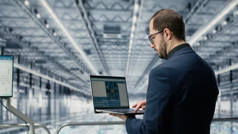 Engineer man reviewing semiconductors smart factory schematics with laptop Stock Footage 333384253