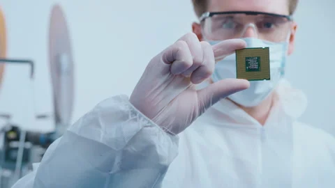 Engineer man  in sterile suit is holding Microchip with symbols in modern des Stock Footage 158176985