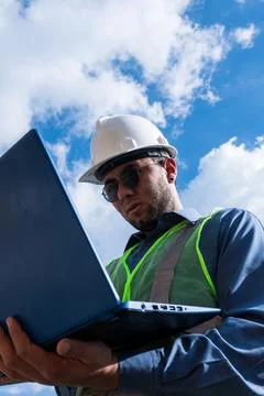 Engineer man working and looking laptop in sunny day Stock Photos