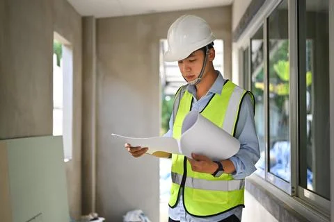 Engineer man working at blueprints and checking building construction progress Foto stock