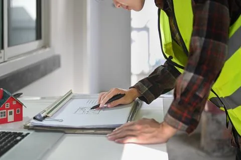 Engineer man working at blueprints and checking building construction progress Foto stock
