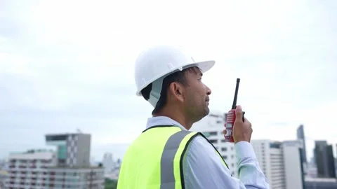 Engineer man in a yellow vest is pointing at something while talking Stock Footage 280732523