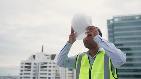 Engineer man in a yellow vest is standing on a rooftop. Stock Footage 280732520