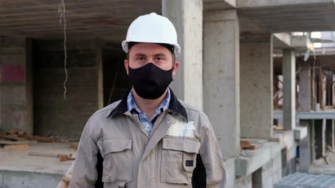 Engineer in mask and hardhat stands with placard Lost my job due covid-19 Stock Footage 144519095
