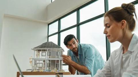 Engineer measure model while coworker using laptop analysis data. Tracery Stock Photos