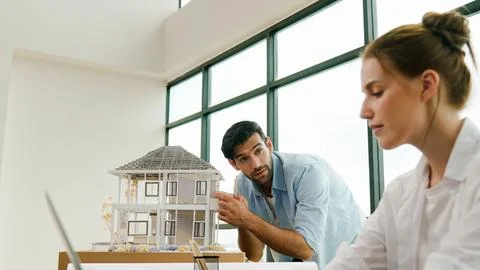 Engineer measure model while coworker using laptop analysis data. Tracery Stock Photos