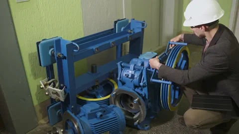 Engineer measures parameters of elevator electric motor before installation. Stock Footage 200131284