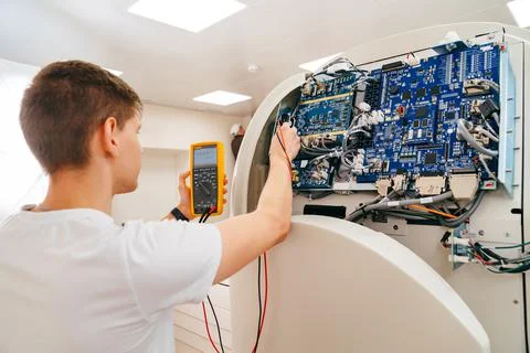 The engineer measures the voltage in the electrical appliance. Stock Photos