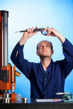 Engineer measuring with caliper against light Stock Photos