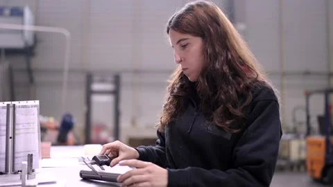Engineer measuring the size of metal piece in a factory Stock Footage 261224031