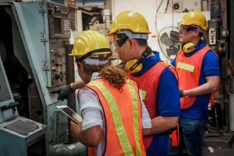 Engineer with  mechanical worker checking on production in a factory. Stock Photos