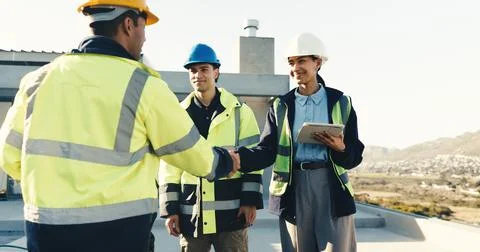 Engineer, meeting and handshake at construction site with builder, tablet and Stock Photos