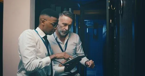 Engineer, men and planning with tablet, server room and teamwork for software Stock Photos