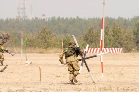 Engineer with mine detector move and make a pass Stock Photos