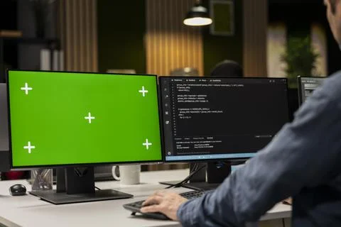 Engineer in office automating tasks using scripts on green screen PC 写真素材