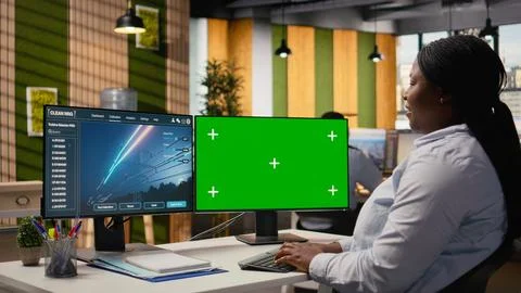 Engineer in office using electrical grid infrastructure data on green screen PC Stock Photos