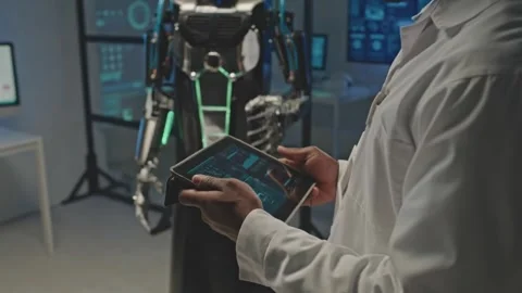 Engineer Operates Advanced Humanoid Robot Using a Digital Tablet Stock Footage 321379042