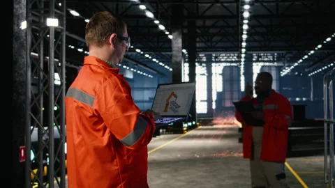 Engineer operates automation software on a laptop to control robot equipment Stock Footage 321914685