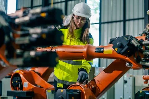 Engineer operates robotic arm in modern manufacturing facility during dayli.. Stock Photos