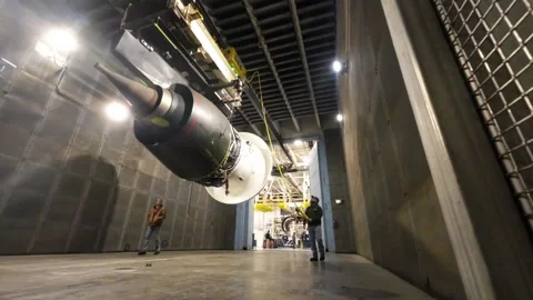 Engineer operating overhead gantry to move aircraft engine at overhaul facility Stock Footage 231690475