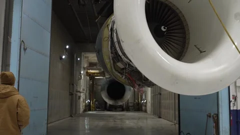 Engineer operating overhead gantry transporting aircraft engine part  Stock Footage 231690435