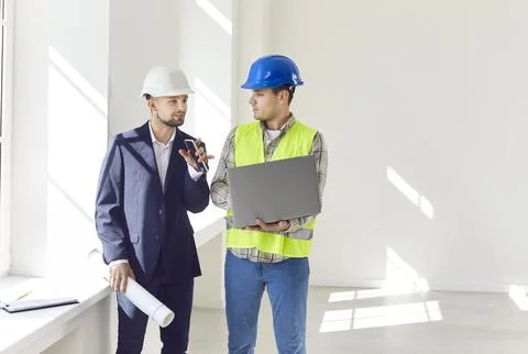 Engineer or architect consulting builder about details of construction and Stock Photos