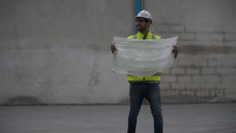 Engineer or architect examining blueprint and  checking plans in construction Stock Footage 146818757