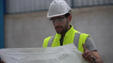 Engineer or architect examining blueprint and  checking plans in construction Stock Footage 146819014