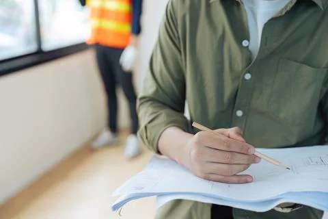 Engineer or architect holding a pencil working on the blueprint at the Foto stock