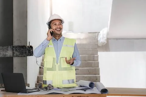 Engineer or Architect with protective safety helmet checking using smartphone 写真素材