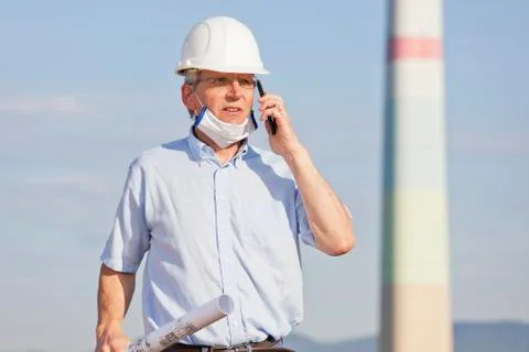 Engineer or architect wearing a face mask beause of coronavirus and blueprint Stock Photos