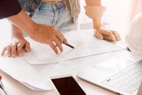 Engineer or architect working and discussing with blueprint and holding penci Foto stock