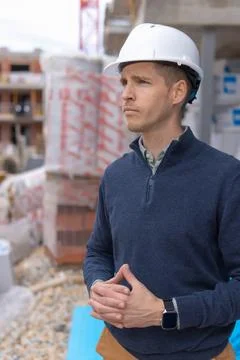 Engineer or builder standing focused at a construction site. Observing prog.. Stock Photos