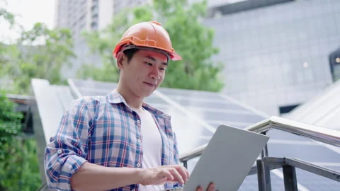 Engineer or construction worker Asian man is using laptop to check solar cell Stock Footage 142702684